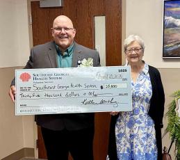 Southeast Georgia Health System Vice President and Administrator Glenn Gann, left, and Volunteer Services President Peggy Tuten pose for a photo with a check from Volunteer Services.