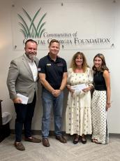 Keeva Kase, from left, executive director of the Communities of Coastal Georgia Foundation; Mitch Blyler, past president of the Rotary Club of Camden County; Cheryl Aston, Wee Read program coordinator and local Kiwanis Club of St. Marys member; and Celia Young, founder of Helping People in Need pose for a photo after Young donated $500 to the local Wee Read program.