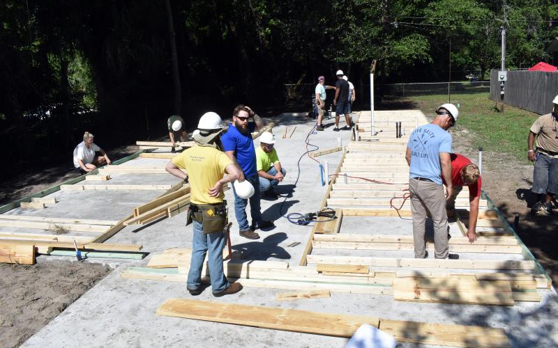 Taylor Tyson watches Lockheed Martin volunteers layout the framing for her Habitat house.