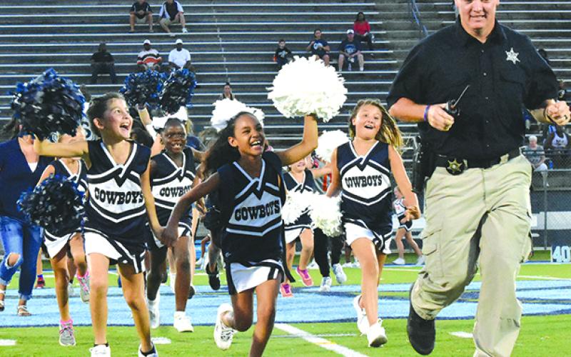 Youth football players, cheerleader and their coaches participate in rec league night at the high school football games.