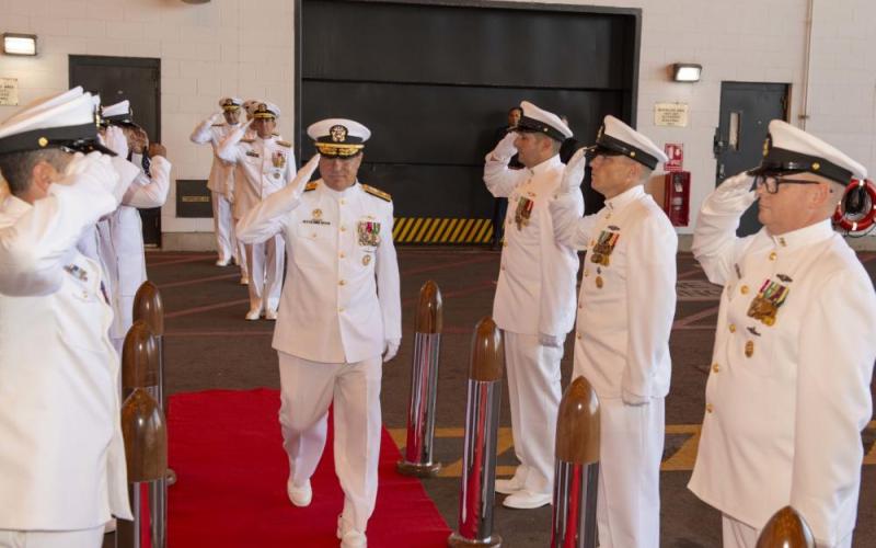 Rear Adm. John Spencer, outgoing commander of Submarine Group Ten, salutes the side boys during a change of command ceremony.