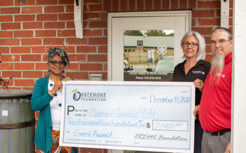 OREMC Foundation Trustee Sonya Walker presents a grant to Shawnie Sahadeo, 4-H Agent, and Shawn Clark, 4-H Educator, at Camden County 4-H to support Project Achievement.