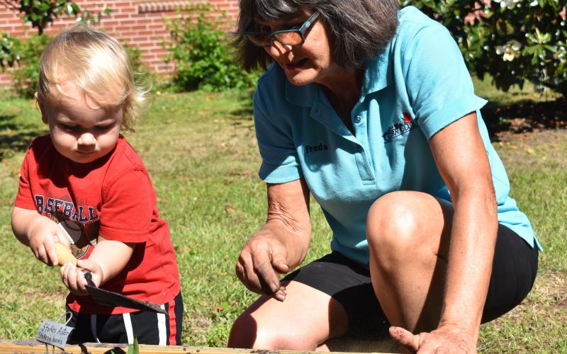 Bart Meyer, helps Freda Malphurs during the unveiling of the St. Marys Public Library’s new community garden.