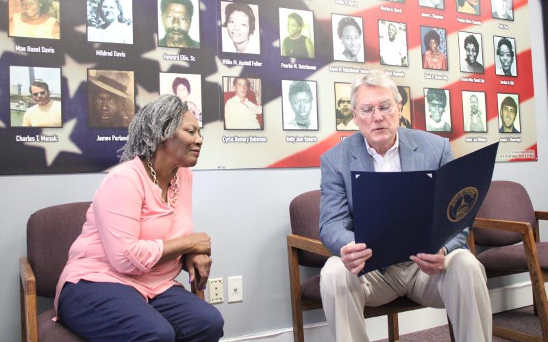 Thiokol Memorial Project CEO and President Jannie Everette, left, listens as state Sen. Michael Hodges (R-Brunswick) reads a resolution memorializing the 30 Woodbine Thiokol Chemical Plant employees who died during the Vietnam War.