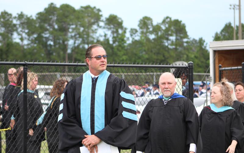 Camden County Schools Superintendent John Tucker, left, leads Camden County High School faculty onto the field during the 2021 graduation ceremony at Chris Gilman Stadium.