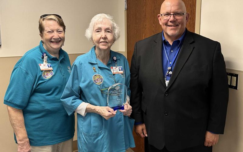 Southeast Georgia Health System Camden Campus Volunteer Services President Kathleen Worthing, left, and Camden Campus Vice President and Administrator Glenn Gann, right, honor the volunteer of the year, Lansie Manning.