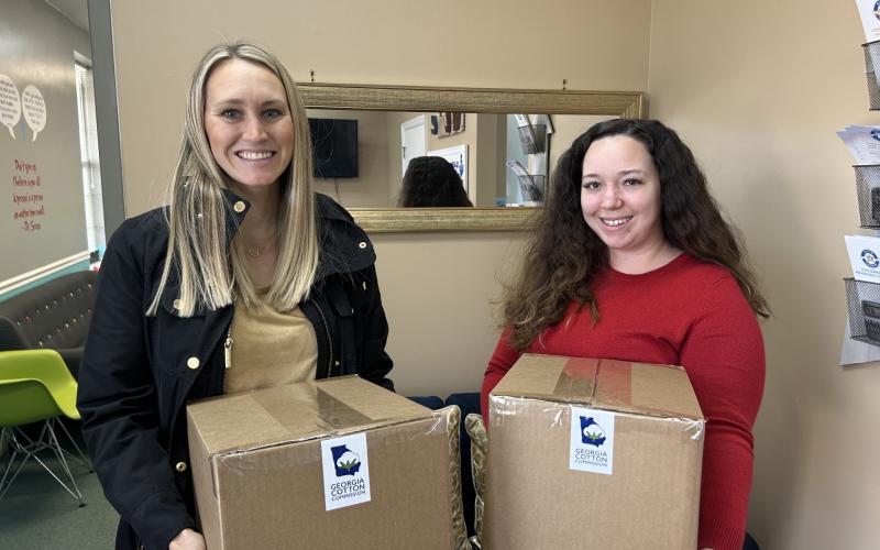 Georgia Cotton Commission Education and Outreach Specialist Caroline Gentry, left, presents Safe Harbor Children Advocacy Center’s Brionna Jones with 125 pairs of socks on behalf of the state’s 3,000 cotton farmers.