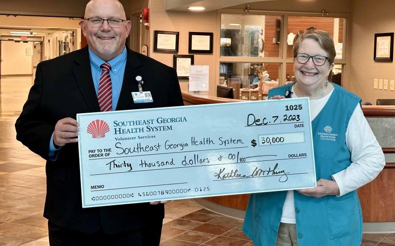 Southeast Georgia Health System Camden Campus Vice President and Administrator Glenn Gann, left, accepts a $30,000 donation from Volunteer Services President Kathleen Worthing.