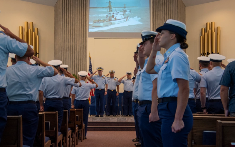 Coast Guard members salute during the playing of the national anthem during a decommissioning ceremony for the Coast Guard Cutters Sea Dog and Sea Dragon in St. Marys.