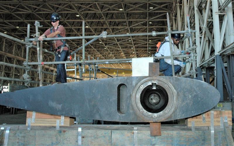 Shop 64A shipwright apprentices adjust a stanchion rig on the topside of a submarine fairwater plane at Naval Submarine Base Kings Bay.