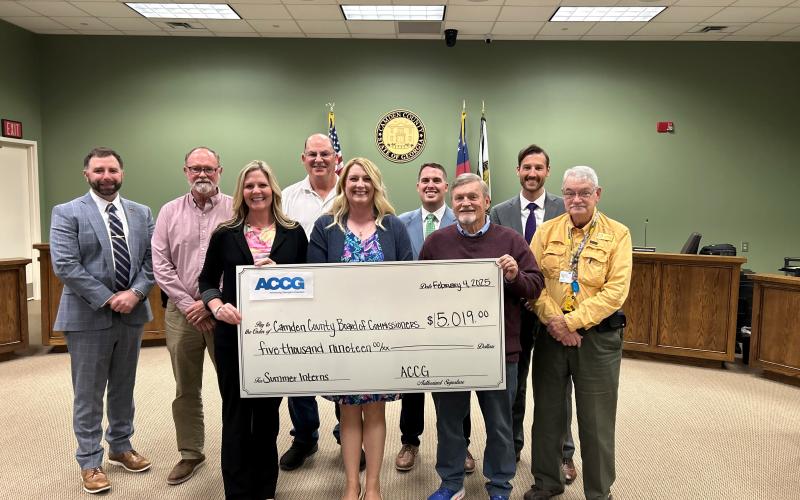 Camden County Administrator Shawn Boatright, from left, Commissioner Robbie Cheek, Communications Director Kristen Kennedy, Chairman Ben Casey, Grants Manager Julie Haigler, Commissioners Cody Smith and Martin Turner, Deputy County Administrator Seth Collins and Commissioner Jim Goodman show off a grant the county received for its internship program.