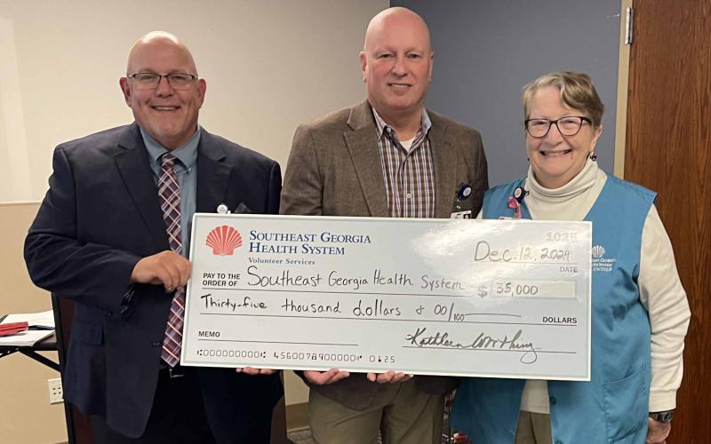 Southeast Georgia Health System Camden Campus Vice President and Administrator Glenn Gann, former CEO/President Scott Raynes and Camden Campus Volunteer Services President Kathleen Worthing stand together after the local volunteers donated $35,000 to the health system. 