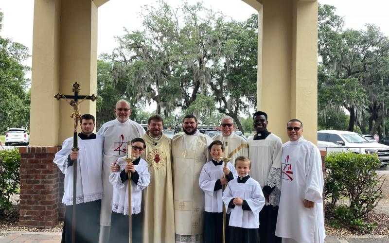 Jared Miller, center, of Woodbine, is studying to be a Catholic priest. The photo was taken at Our Lady Star of the Sea in St. Marys with current pastor Father Mariusz Fuks, Deacons Tim Hughes, Henry Nieves and Paul Lang, and altar servers from the parish.