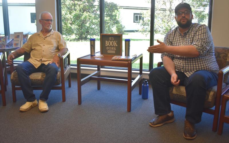 Author Joshua Sharpe, right, talks about his research that helped lead to the exoneration of Dennis Perry, left, who was convicted in the 1985 double murder of Harold and Thelma Swain at Rising Daughter Baptist Church.