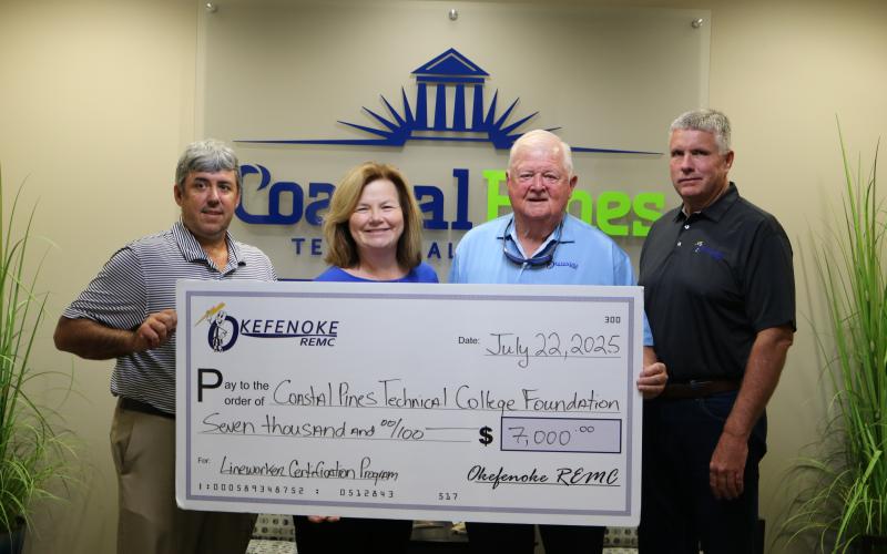 Chad Swanson, Dean for Academic Affairs, and Stephanie Roberts, Executive Director of College Advancement, accept a donation to the Coastal Pines Technical College Foundation from Okefenoke Rural Electric Membership Corporation presented by Board President Wayne Combs and Board Director Craig Morgan.