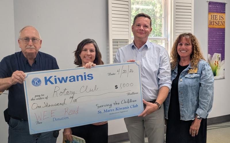 St, Marys Kiwanis Club President Dale Law, from left, Rotary Club of Camden County Service Committee Chairwoman Amanda Blyler, Rotary President Mitch Blyler and retired educator Cheryl Alston hold up a check from the Kiwanis Club supporting the Wee Read Program.