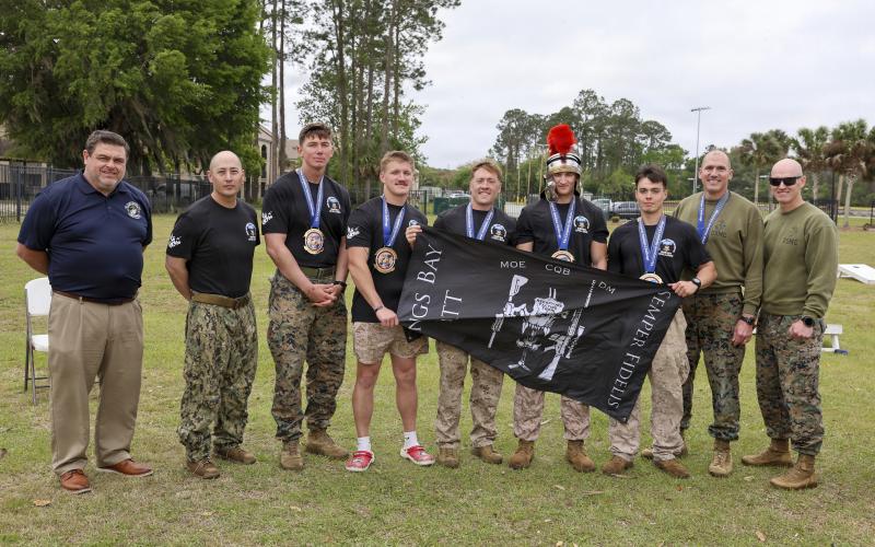 The first-place winners of the Marine Corps Security Force Battalion (MCSFBn) Kings Bay’s 15th annual Dunham Challenge, pose for a photo with, from left, Jeremiah Workman, assistant secretary, Veterans’ Employment and Training Service (VETS), Lt. Col Joseph Moeller, MCSFBn commanding officer, and Sgt. Maj. Cory Daly, MCSFBn command sergeant major, at Naval Submarine Base Kings Bay.