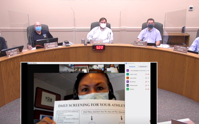 Dr. Eugenia Ngo-Seidel holds up a chart parents and coaches can use to screen athletes before they attend practices and games. The Florida Department of Health – Nassau has also created one for students. GARY D. MORGAN/FOR THE NEWS-LEADER