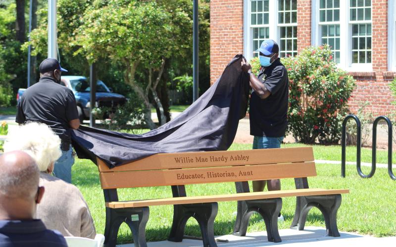 Members of the Elm Street Sportsman Association unveil a bench dedicated to Willie Mae Hardy Ashley at the Peck Center. Ashley taught in Nassau County Schools for 35 years, including then-segregated Peck High School.