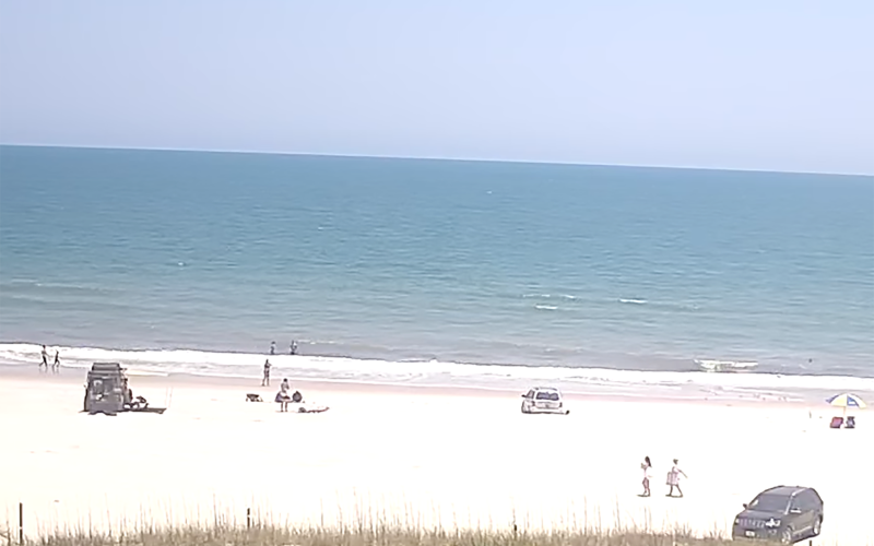 A video of Susan Jakuszewski being run over by a vehicle on the beach behind Sliders Seaside Grill remains online. The video is posted by a user named “Beach Bum” and titled “Live Stream – Sliders Seaside Grill.”