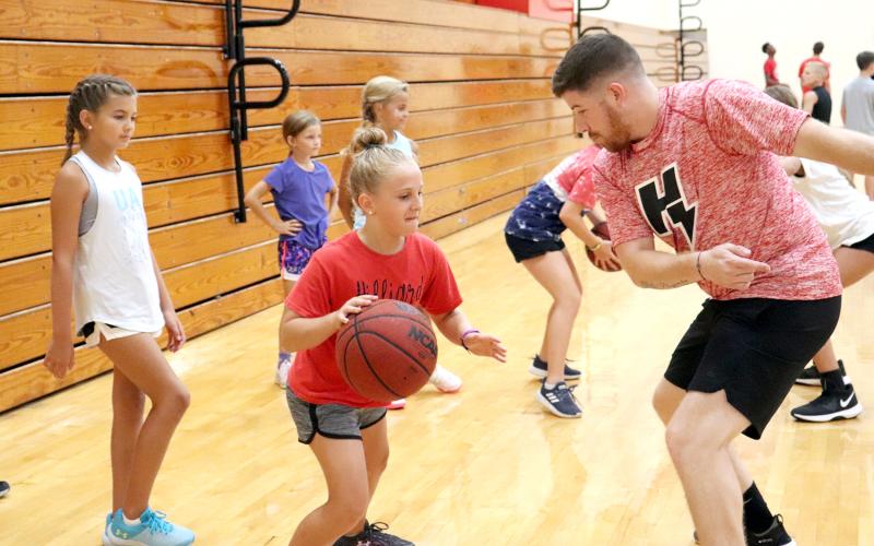 Children ages 7-12 hone their basketball drills as part of the Camp Saunders activities hosted by Hilliard Middle-Senior High School Coach Myron Saunders and the Class 1A state runner-up Flashes boys basketball team in the gym July 15. Forty-four kids participated in the four-day camp, learning the proper way to dribble the ball, defensive tactics and how to hone their skills at the basket. The campers received participation certificates at the conclusion of the camp. 