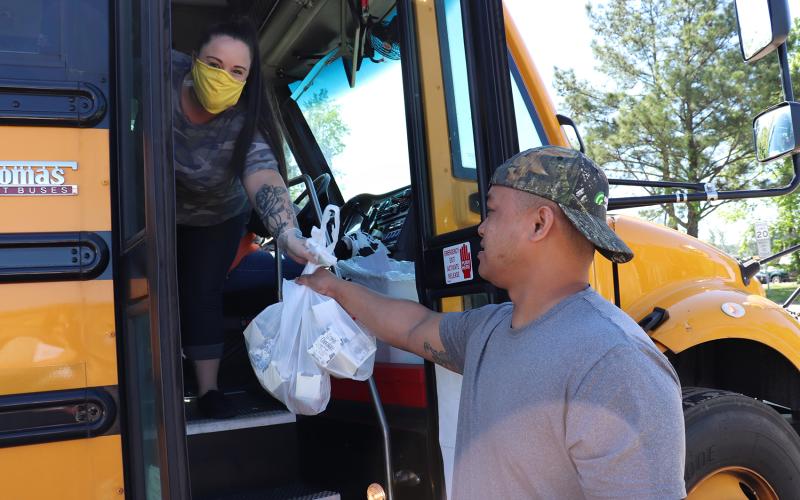 Callahan resident Bobby Llanes collects breakfast and lunch items from Bethany Low during a Nassau County School District meal distribution Friday morning near Amhurst Oaks subdivision.
