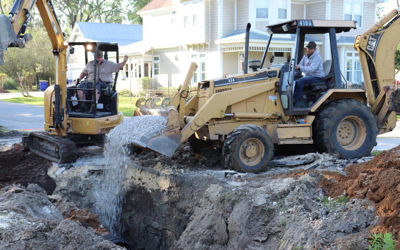 Callahan Public Works employee Ryan Everly unloads gravel recently near water and sewer lines along Dixie Avenue as co-worker Marty Johnson directs him. Photo by Kathie Colgrove