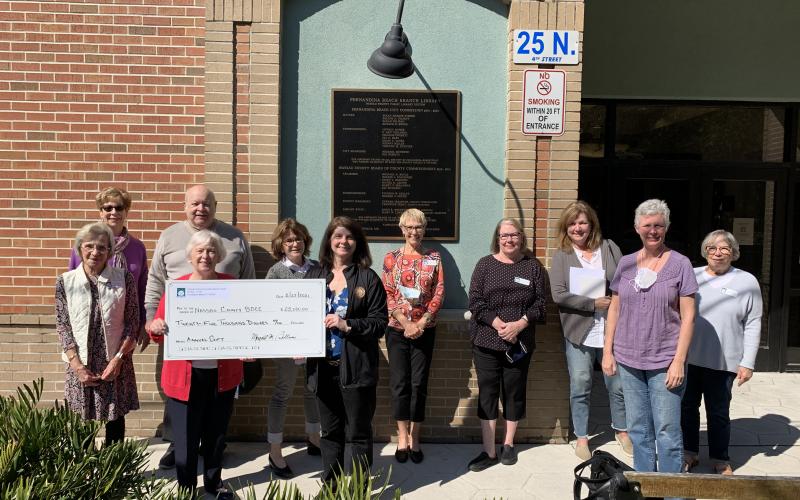 Friends of Fernandina Beach Library President Jody Mackle, front row, from left, presents the group’s annual gift to Nassau County Library Director Dawn Bostwick. Back row: Other board members attending the event were Terri Dean, Joan Sheppard, Chuck Comeau, Ann Freeman, Mary Louise Hester, Christine Meehan, Claudia Zane, Vicki Harnage Whittemore and Margaret Bellucci. Board members not pictured: Hope Foley, Ann Martin, Virgina Mealing and Sara Moerman.