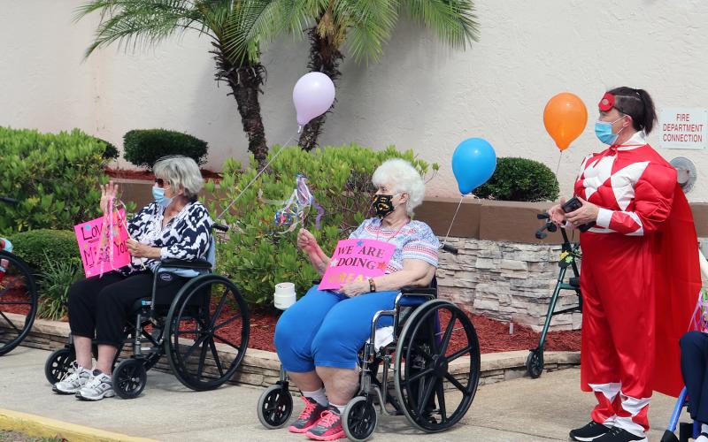 Families, friends and health professional participate in a community parade through the Life Care Center of Hilliard campus Friday morning. Citizens created posters and decorated vehicles with greetings to show their love to residents as they sat outside or stood inside near windows and waved to motorists. 