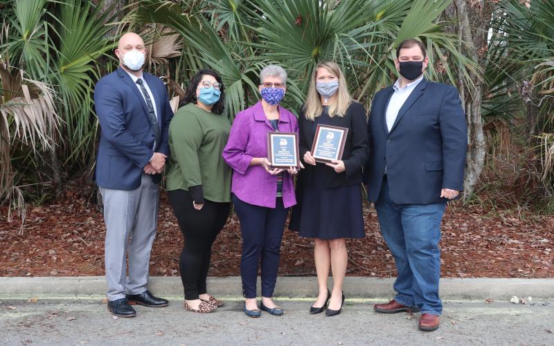 Nassau County Manager Taco Pope, from left, Planning and Economic Opportunity Department Planner/GIS analyst Abby Weiss, Planning and Zoning Board member Linda Morris, Northeast Florida Regional Planning CEO Beth Payne and Nassau County Board of County Commissioners Chairman Thomas Ford pose with the two leadership awards the county received.