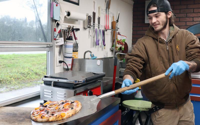 Krusty Kraken’s Austin Downing prepares to box an oven-baked pizza.