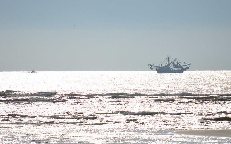 A recreational fishing boat shares the ocean with a commercial shrimp boat.  Florida Fish &amp; Wildlife Conservation Commission