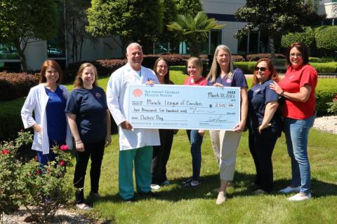 Southeast Georgia Health System’s Camden Campus Patient Care Services Jessica Wildes and Medical Staff Chief Dr. Thomas C. Whitesell Jr. participate in a check-passing with Miracle League representatives Ashley Lacoste, Erica Boyd, Cassey McCutcheon, Sarah Johnsen, Tish Fredericks and Mollie Norman.