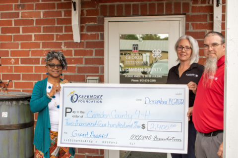 OREMC Foundation Trustee Sonya Walker presents a grant to Shawnie Sahadeo, 4-H Agent, and Shawn Clark, 4-H Educator, at Camden County 4-H to support Project Achievement.