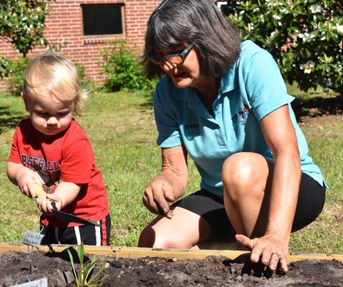 Bart Meyer, helps Freda Malphurs during the unveiling of the St. Marys Public Library’s new community garden.
