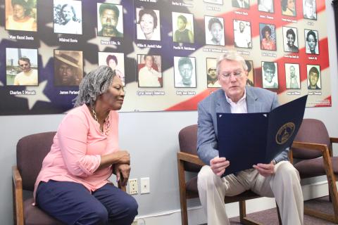 Thiokol Memorial Project CEO and President Jannie Everette, left, listens as state Sen. Michael Hodges (R-Brunswick) reads a resolution memorializing the 30 Woodbine Thiokol Chemical Plant employees who died during the Vietnam War.