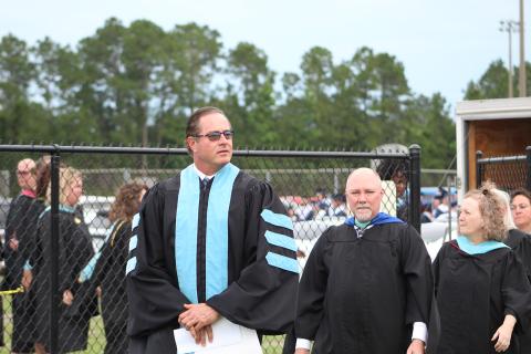 Camden County Schools Superintendent John Tucker, left, leads Camden County High School faculty onto the field during the 2021 graduation ceremony at Chris Gilman Stadium.