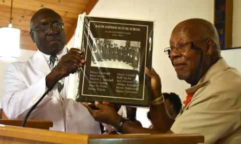 Tommie Mitchell, right, a member of the Ralph Johnson Bunche High School class of 1952, presents a plaque of the graduating class to Artie Jones, president of the high school and Camden County Training School alumni association.