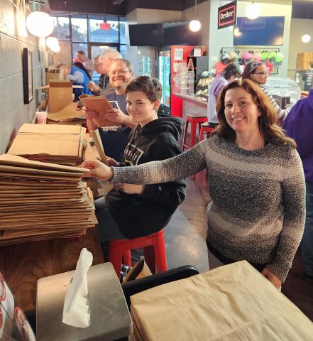 Kyle Rapp, from left, Ashton Blyler and Amanda Blyler participate in preparation for the Rotary Club of Camden County’s Fill the Bag food drive.
