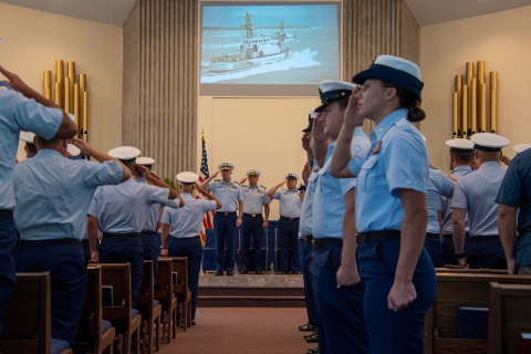 Coast Guard members salute during the playing of the national anthem during a decommissioning ceremony for the Coast Guard Cutters Sea Dog and Sea Dragon in St. Marys.