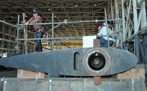Shop 64A shipwright apprentices adjust a stanchion rig on the topside of a submarine fairwater plane at Naval Submarine Base Kings Bay.