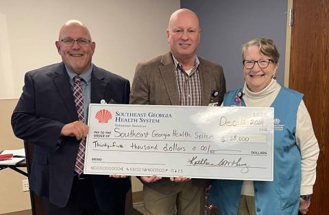 Southeast Georgia Health System Camden Campus Vice President and Administrator Glenn Gann, former CEO/President Scott Raynes and Camden Campus Volunteer Services President Kathleen Worthing stand together after the local volunteers donated $35,000 to the health system. 