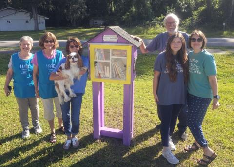 A Little Free Library is located at Woodbine Pharmacy. From left are Janet Heath, Colleen Weinkle, Mickey Silva, Crissy Carter and Ken Duke.