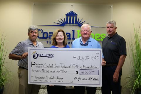 Chad Swanson, Dean for Academic Affairs, and Stephanie Roberts, Executive Director of College Advancement, accept a donation to the Coastal Pines Technical College Foundation from Okefenoke Rural Electric Membership Corporation presented by Board President Wayne Combs and Board Director Craig Morgan.