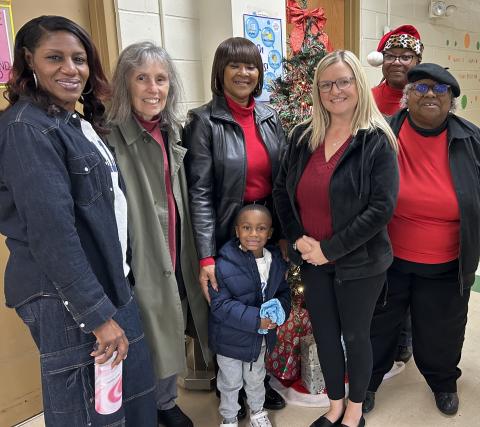 Women United International members pose for a photo with Camden Head Start Program Director Christy Overby after distributing bedtime bags.