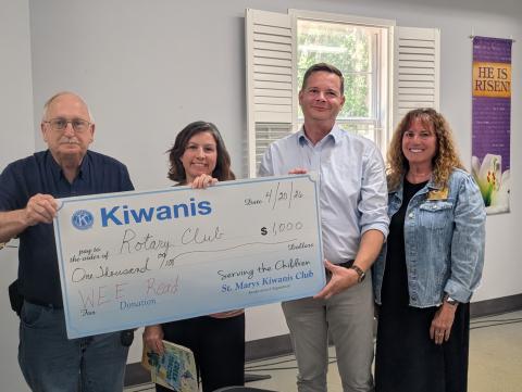 St, Marys Kiwanis Club President Dale Law, from left, Rotary Club of Camden County Service Committee Chairwoman Amanda Blyler, Rotary President Mitch Blyler and retired educator Cheryl Alston hold up a check from the Kiwanis Club supporting the Wee Read Program.