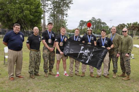 The first-place winners of the Marine Corps Security Force Battalion (MCSFBn) Kings Bay’s 15th annual Dunham Challenge, pose for a photo with, from left, Jeremiah Workman, assistant secretary, Veterans’ Employment and Training Service (VETS), Lt. Col Joseph Moeller, MCSFBn commanding officer, and Sgt. Maj. Cory Daly, MCSFBn command sergeant major, at Naval Submarine Base Kings Bay.