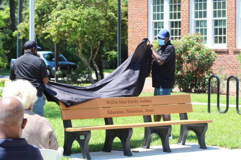 Members of the Elm Street Sportsman Association unveil a bench dedicated to Willie Mae Hardy Ashley at the Peck Center. Ashley taught in Nassau County Schools for 35 years, including then-segregated Peck High School. 