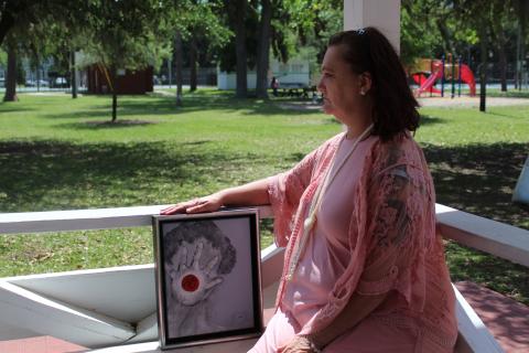 Leighanne Bohrer was a victim of sexual assault, and through the Women’s Center of Jacksonville, she’s received counseling, support and help when dealing with law enforcement officials concerning her allegations. She’s pictured with a piece of artwork from Barbara Kiersh.