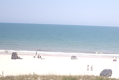 A video of Susan Jakuszewski being run over by a vehicle on the beach behind Sliders Seaside Grill remains online. The video is posted by a user named “Beach Bum” and titled “Live Stream – Sliders Seaside Grill.”